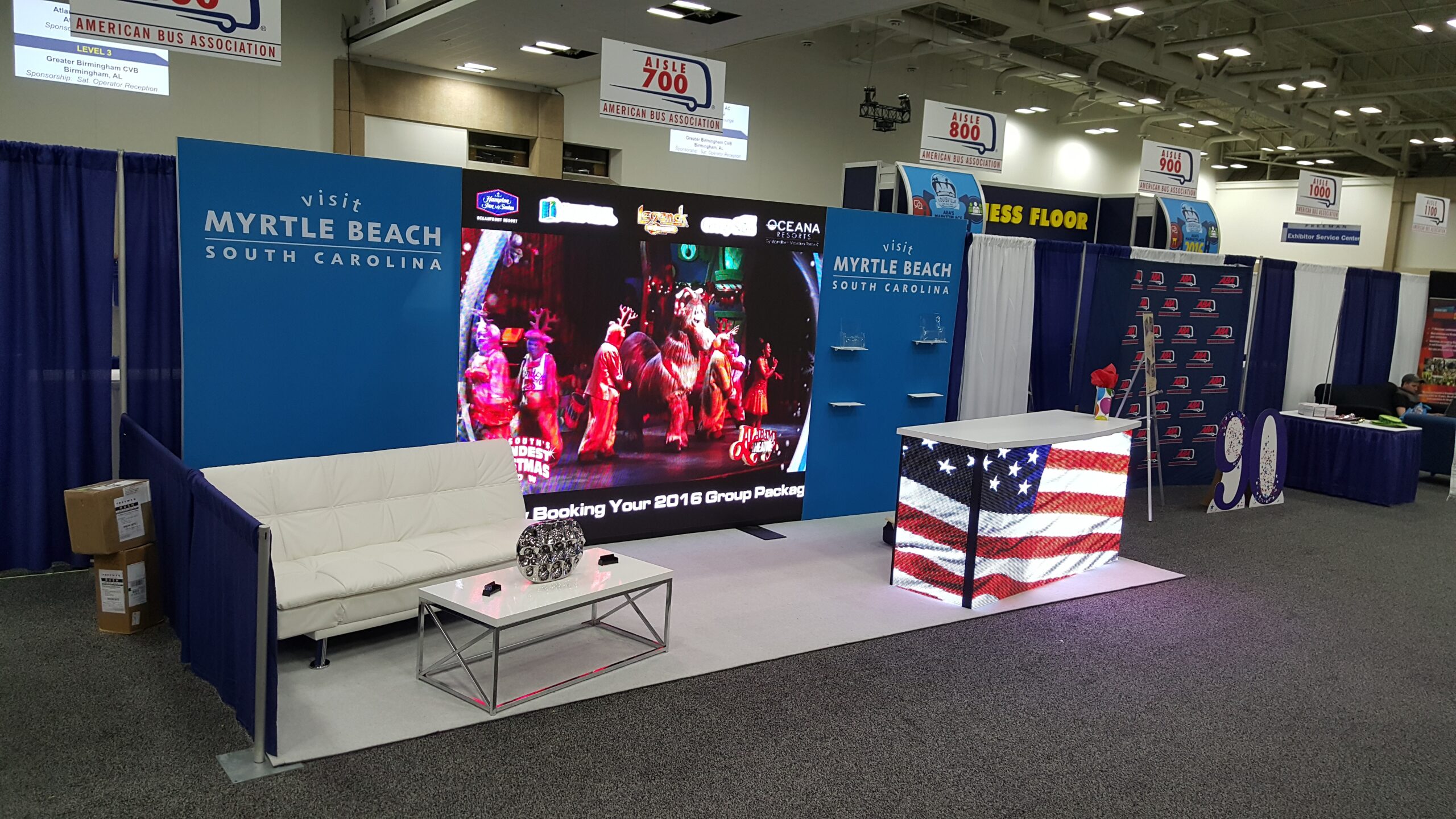 20x10 LED rental booth with video wall, lounge seating, branded counter, open floor space and fast show setup