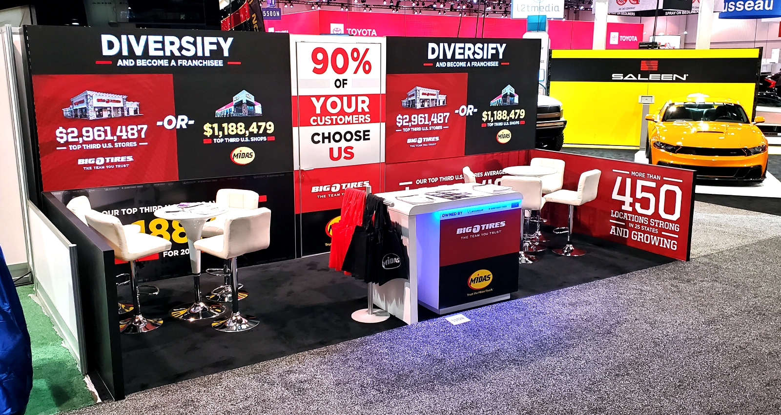 20x10 Las Vegas LED trade show exhibit with dual video walls, branded graphics, seating, counter and strong aisle visibility