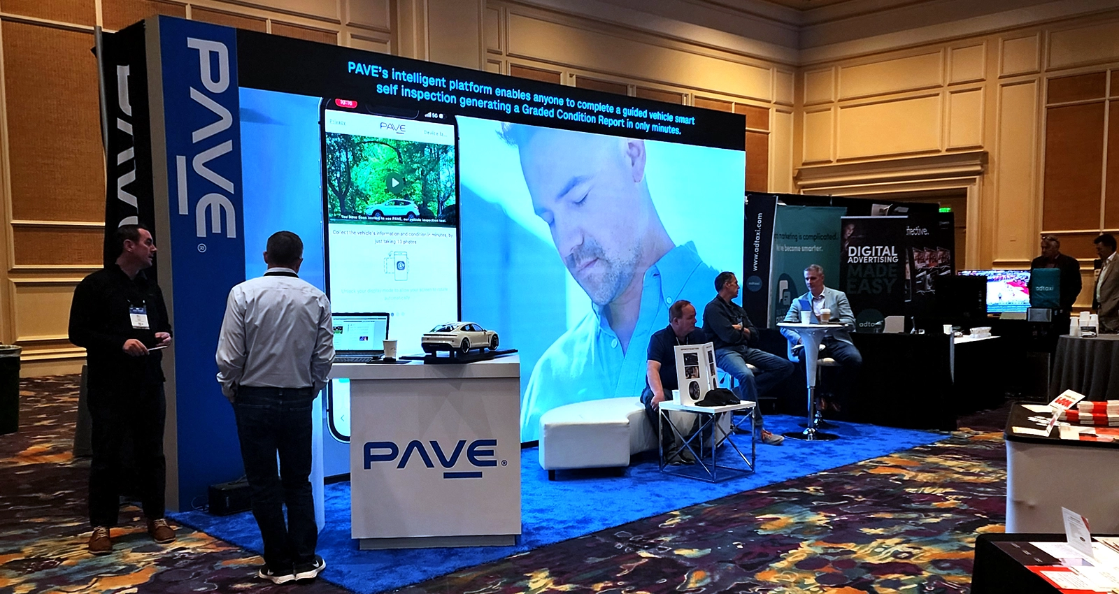20x10 premium LED trade show exhibit with branded structure, large video wall, reception counter and meeting area