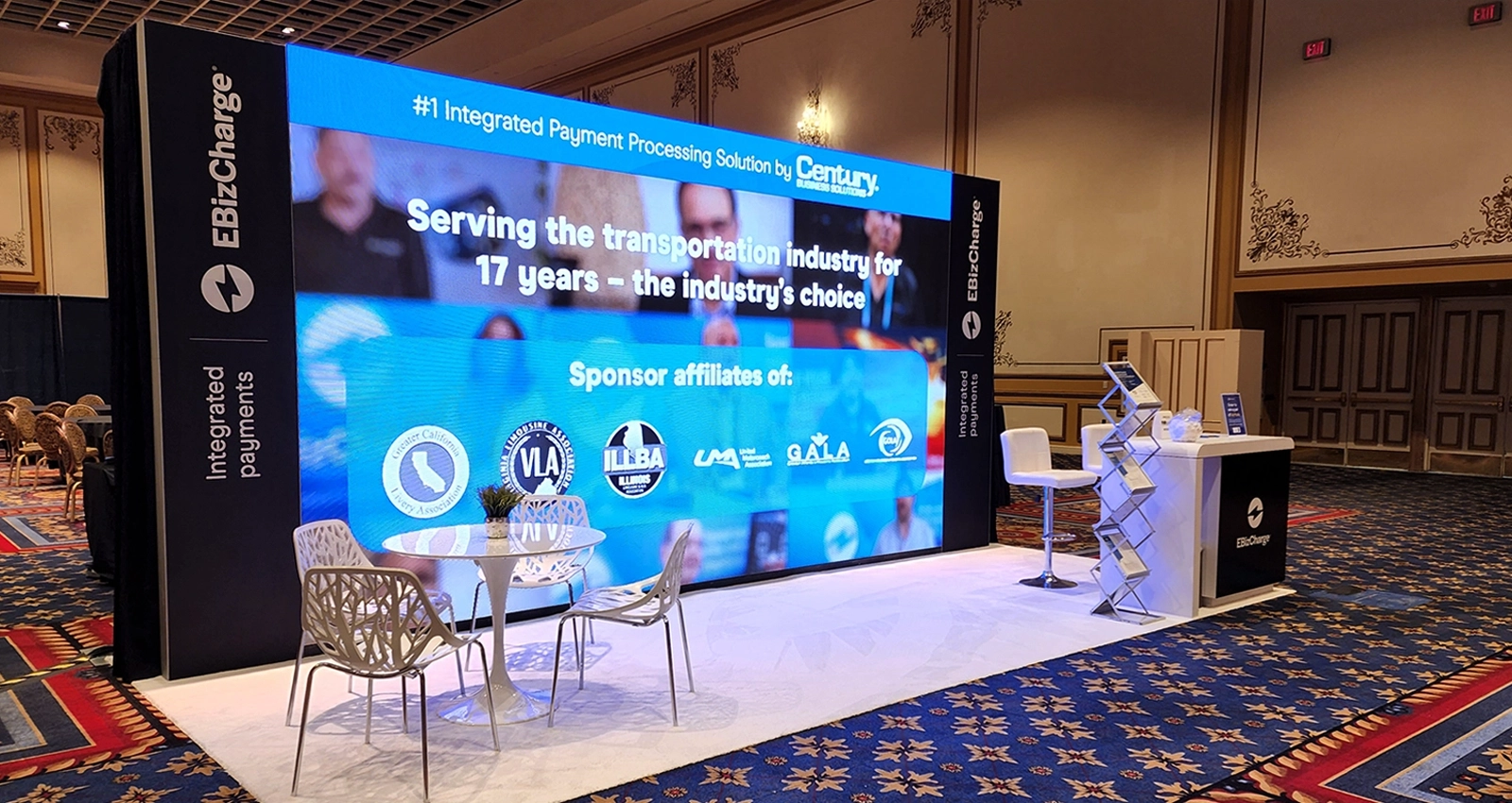 LED video wall display for trade show event with large screen presentation, branded booth graphics, and seating